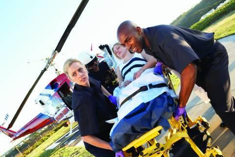 Paramedics escorting patient from ambulance into hospital